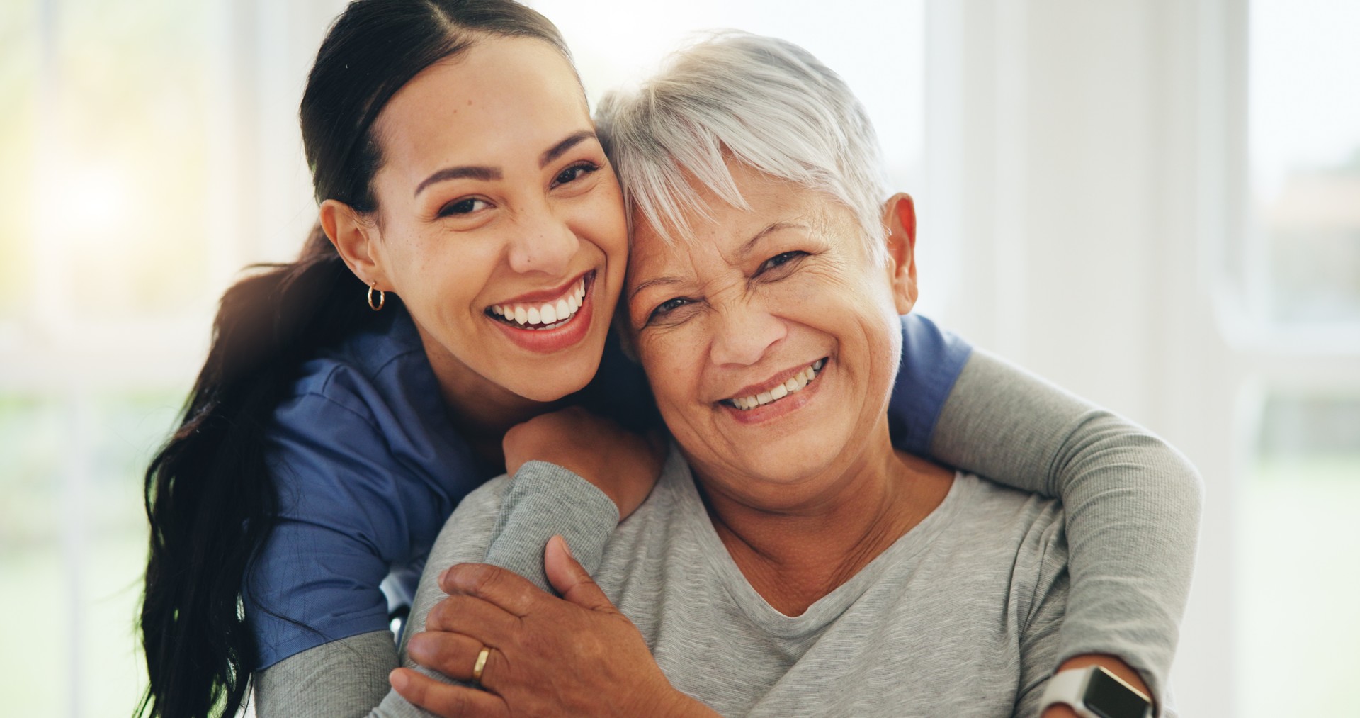 Happy woman, nurse and hug senior patient in elderly care, support or trust at old age home. Portrait of mature female person, doctor or medical caregiver hugging with smile for embrace at house